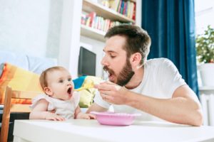 папа кормит ребенка